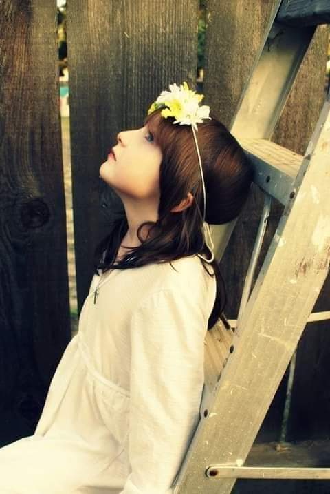 A Child With A Flower In Her Hair